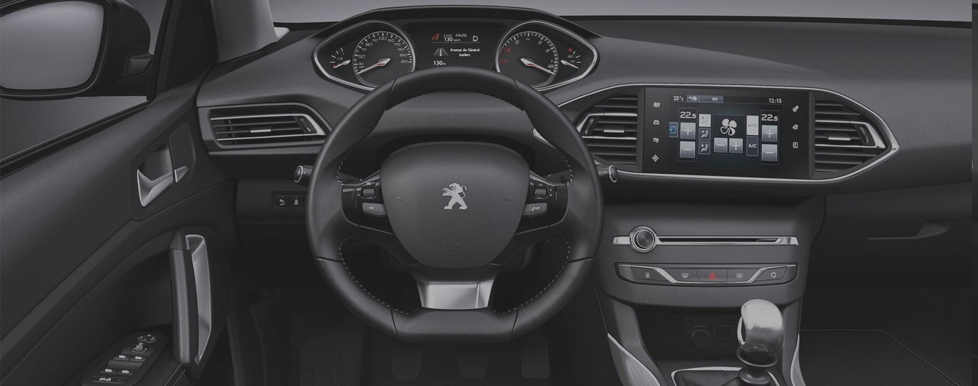 Het stuur en dashboard van een Peugeot lesauto van binnen